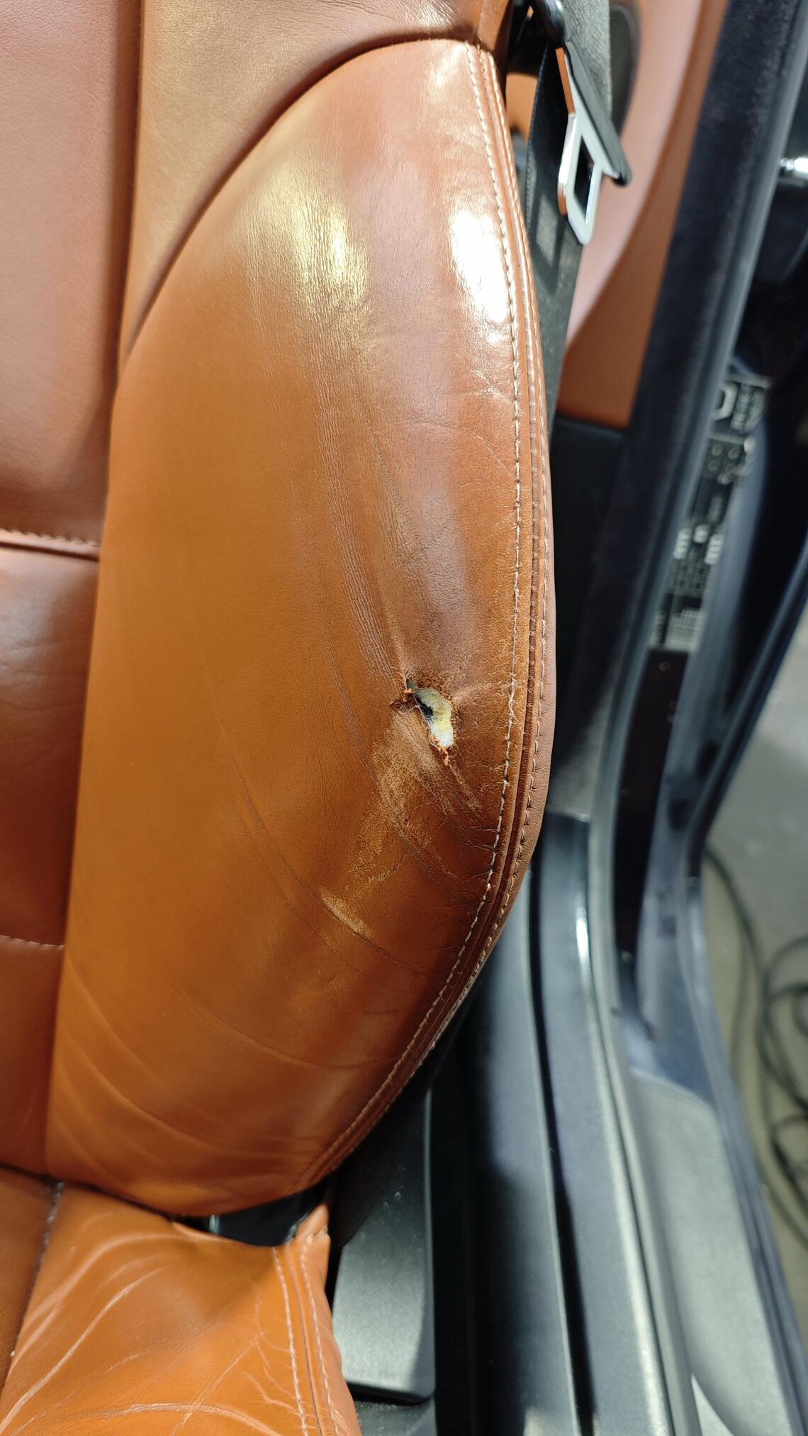 Loch im Autoledersitz